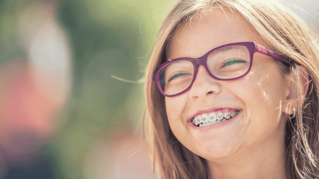 Smiling teen patient with colorful braces at Gladwell Orthodontics