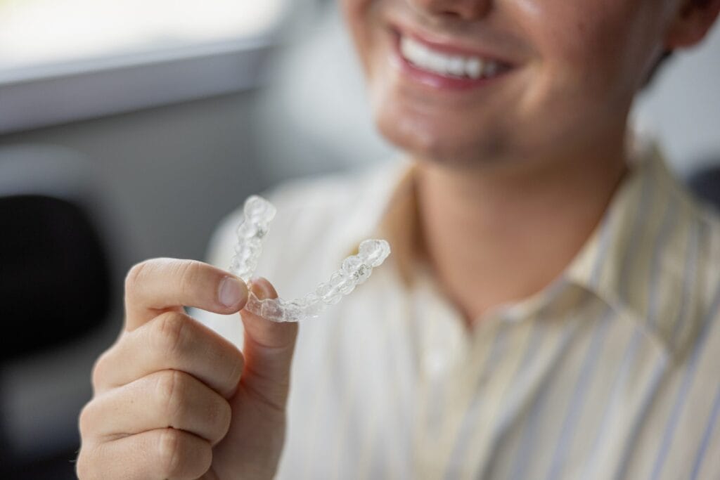 Patient holding an Invisalign clear aligner